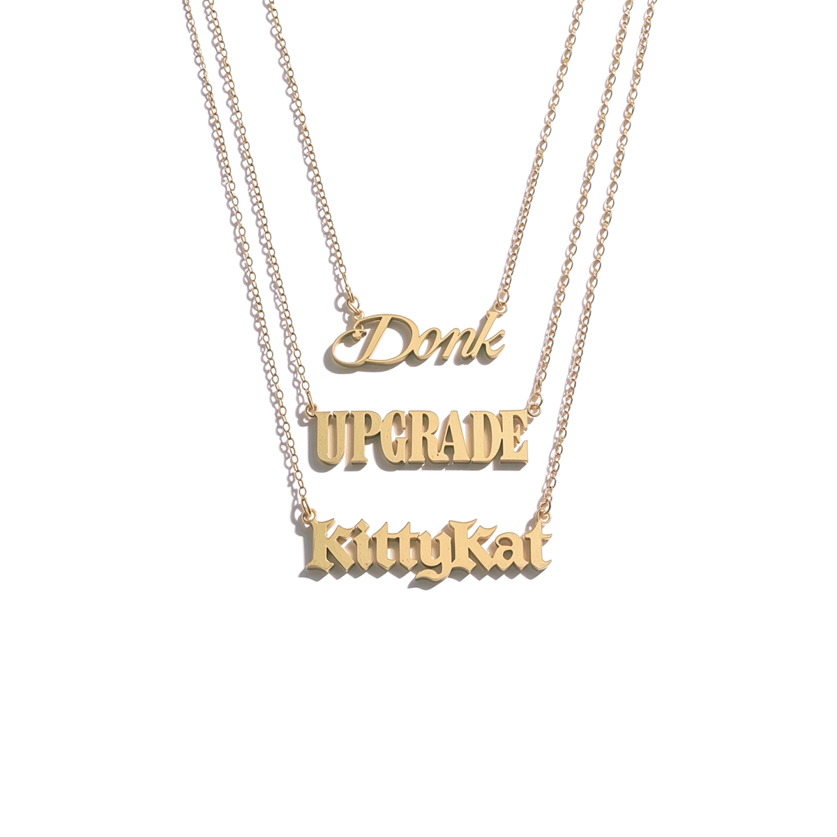 Beyoncé B'DAY Trackplates Side B, three gold nameplate necklaces reading Donk, Upgrade and KittyKat