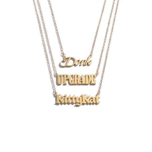 Beyoncé B'DAY Trackplates Side B, three gold nameplate necklaces reading Donk, Upgrade and KittyKat